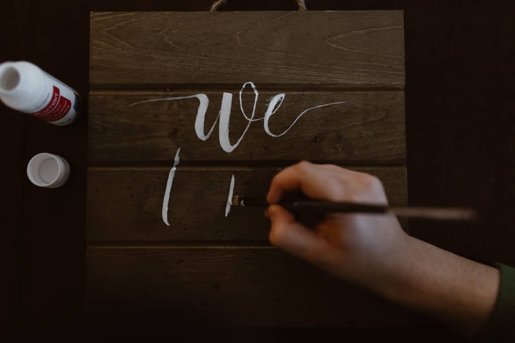 Painting the letters to a hiking elopement sign