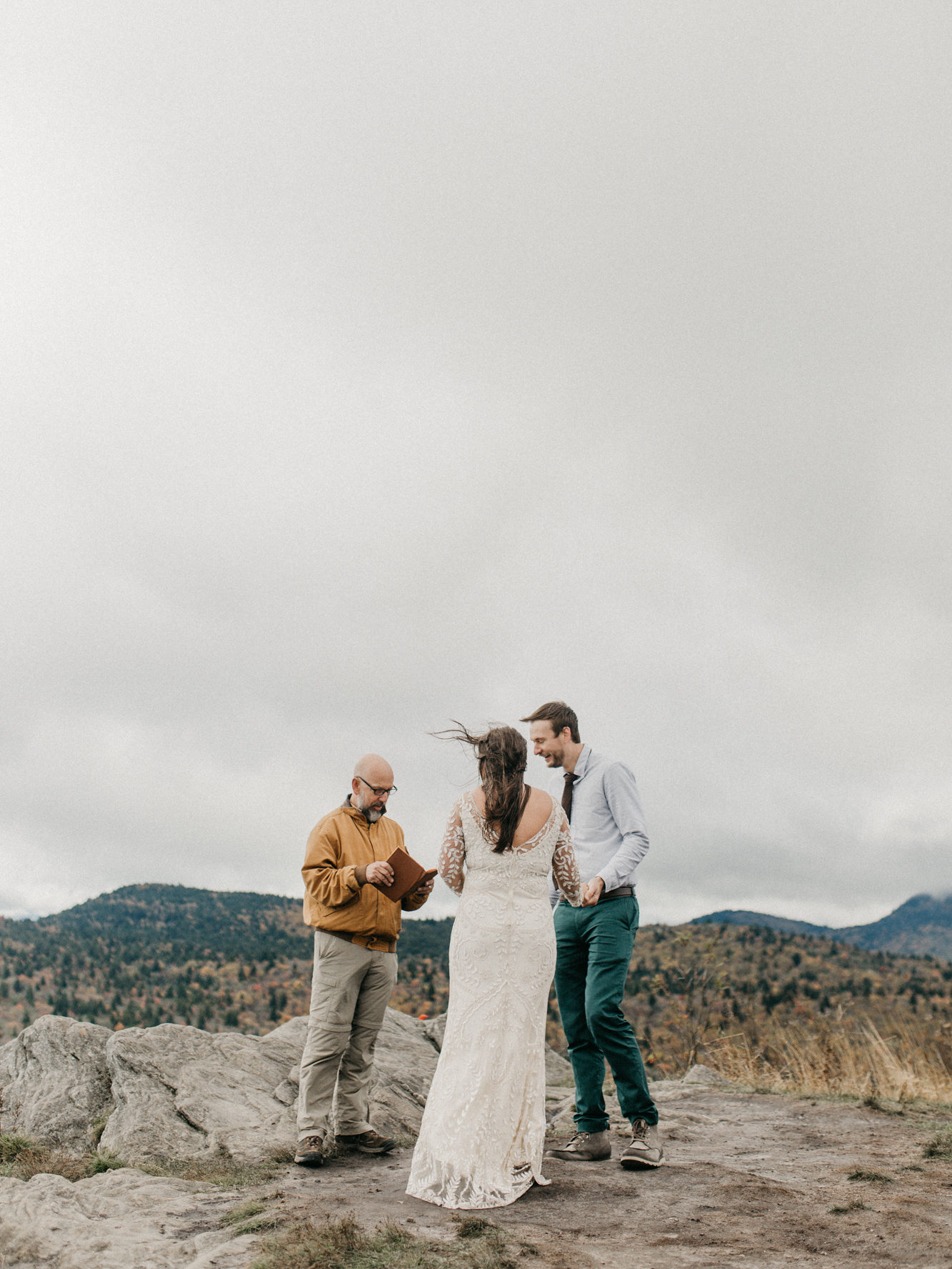 A couple eloping with an officiant in the mountains. 