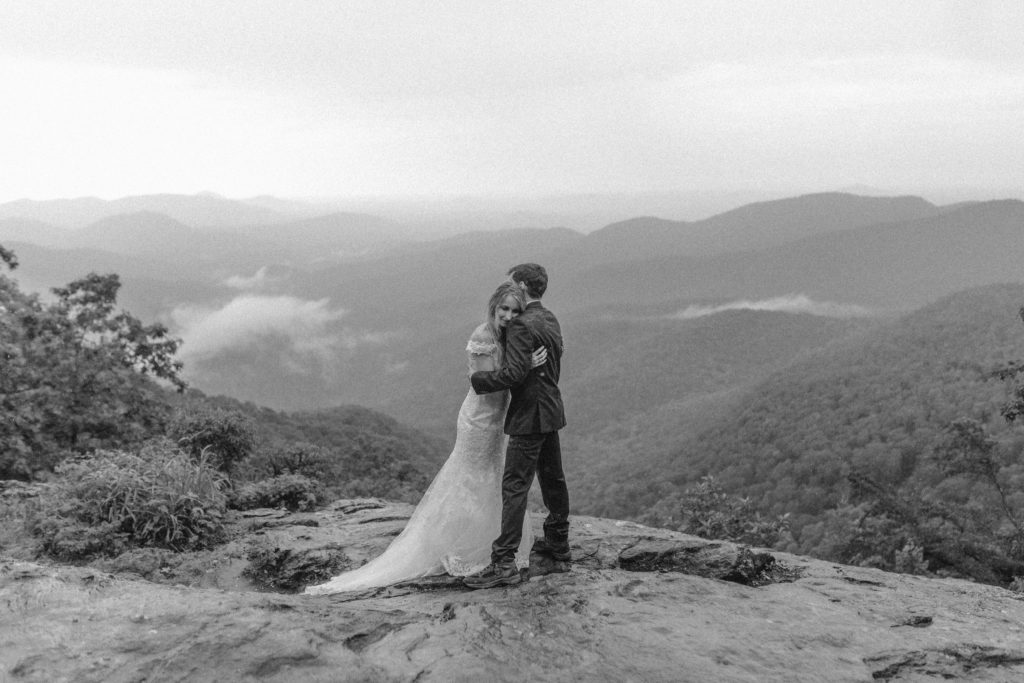 A couple hugging each other as they enjoy the mountain views on their Georgia elopement. 
