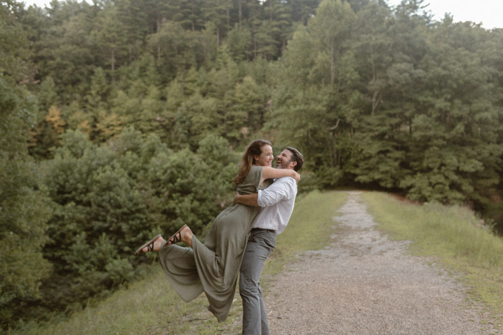 A couple jumping into each others arms on a trail for their engagement shoot. 