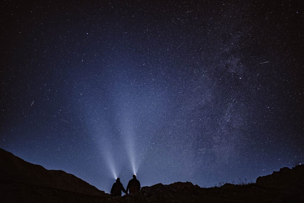 A bride and groom on the morning of their Georgia elopement hiking to their ceremony location with the stars above. 