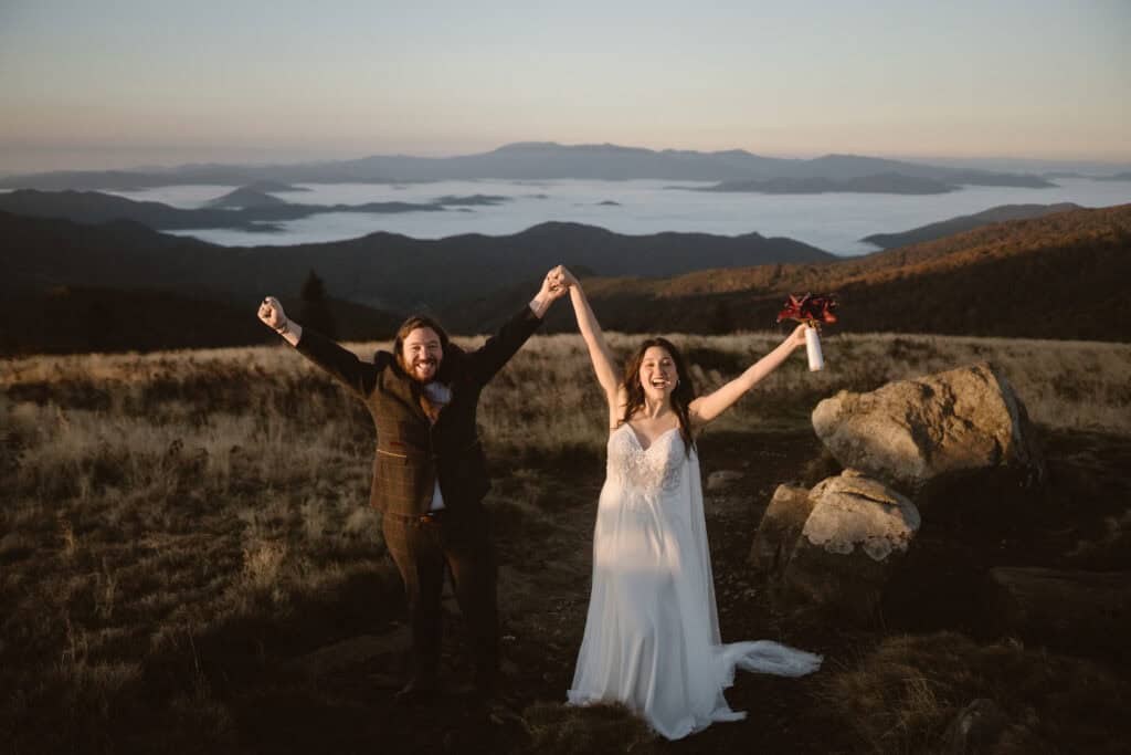 A smiling newly married couple celebrating their sunrise mountain hiking elopement. 
