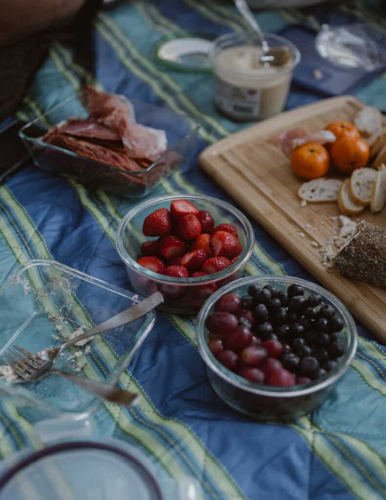 Fruit from a charcuterie board on a picnic blanket. 