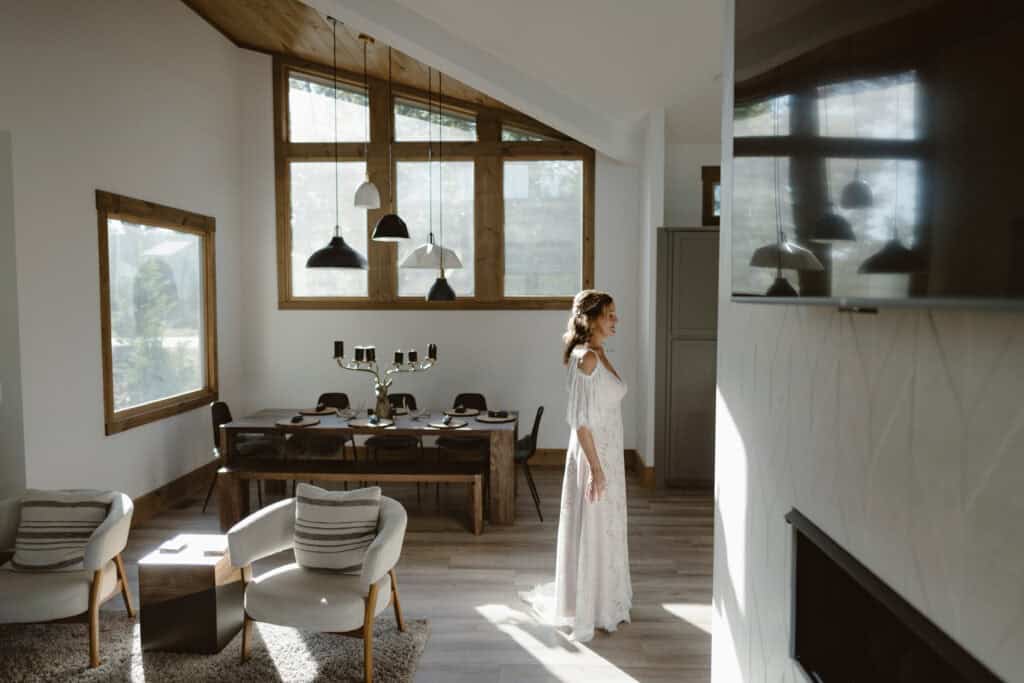 A woman wearing her bridal gown in a bright, light-filled room on her wedding day. 