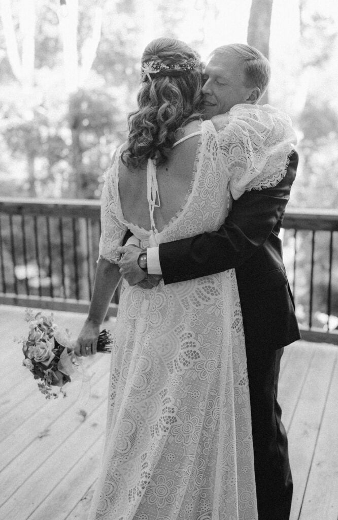 A newlywed couple embracing each other on the porch. 