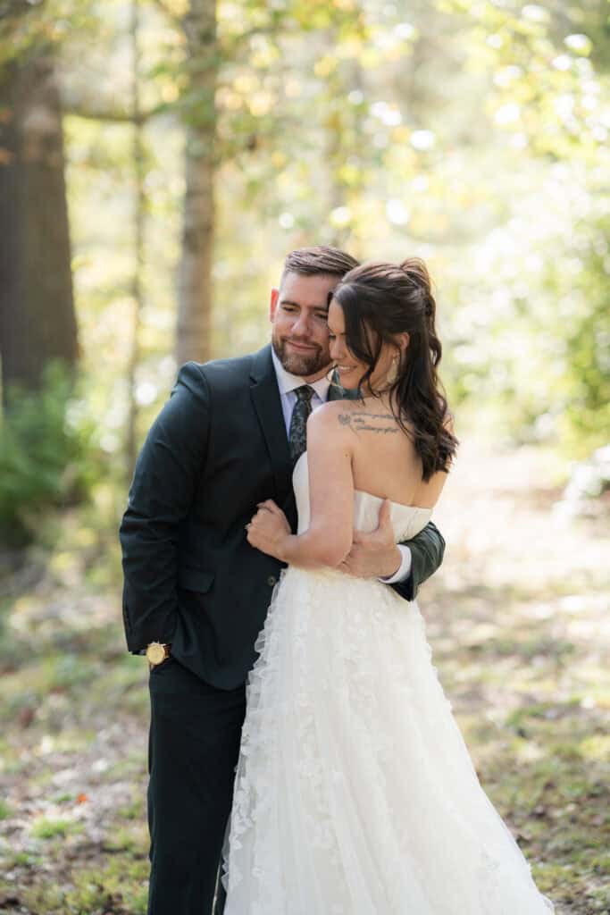 A newlywed couple hugging and embracing each other in the forest. 