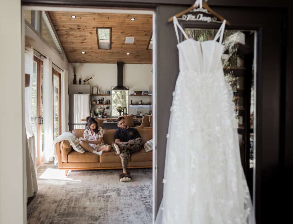 A couple write their private vows while sitting down, their wedding attire blurred in the foreground. 