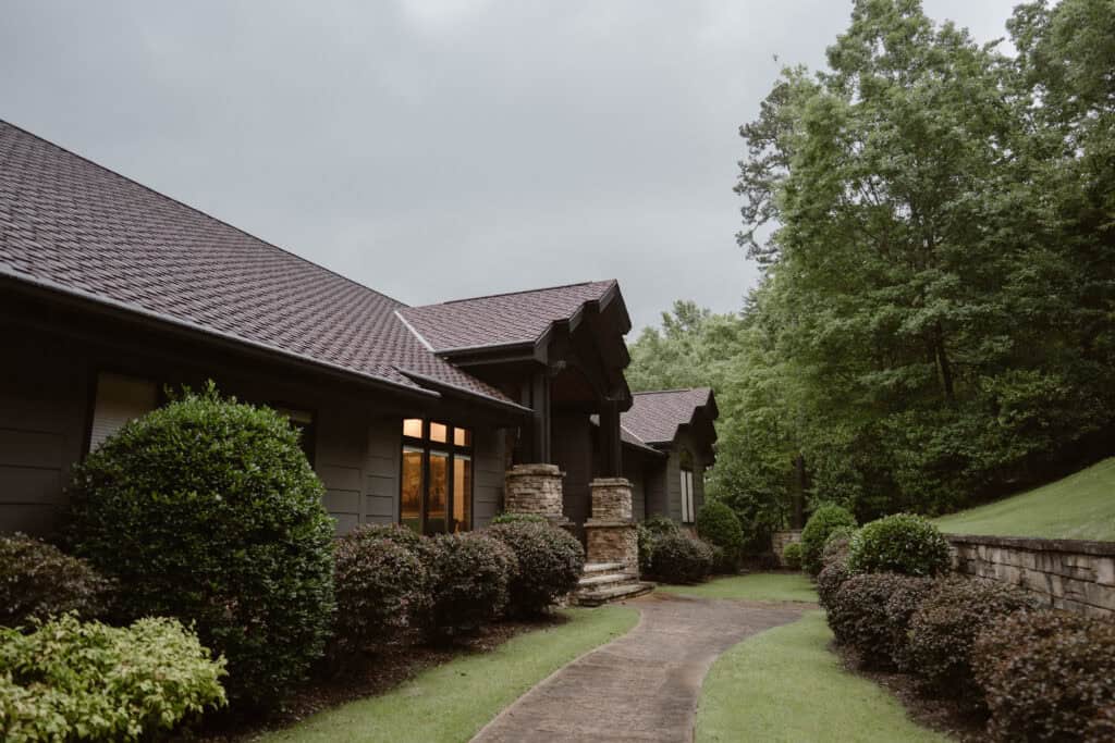 A large cabin with lush greenery. 
