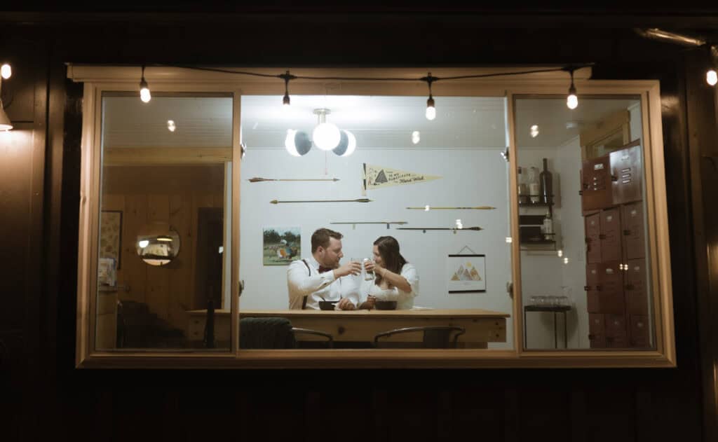 A newlywed couple toasting over their first meal as a married couple. 