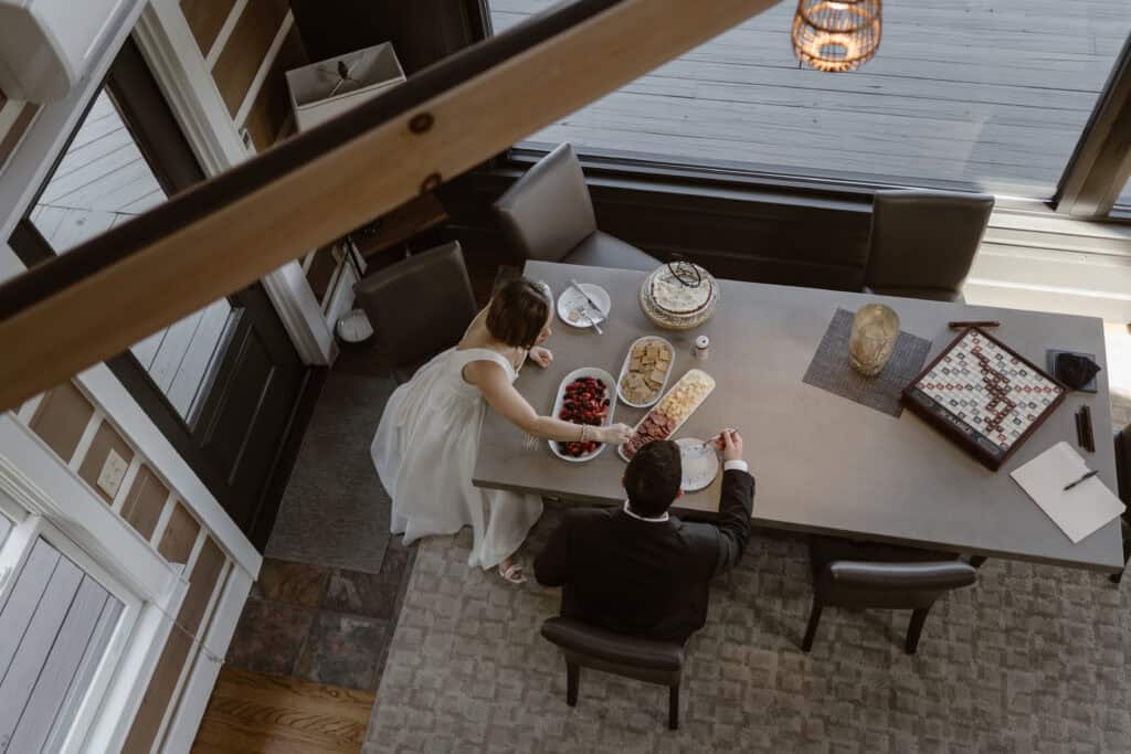 A newlywed couple enjoying a charcuterie board and pie at their Airbnb. 